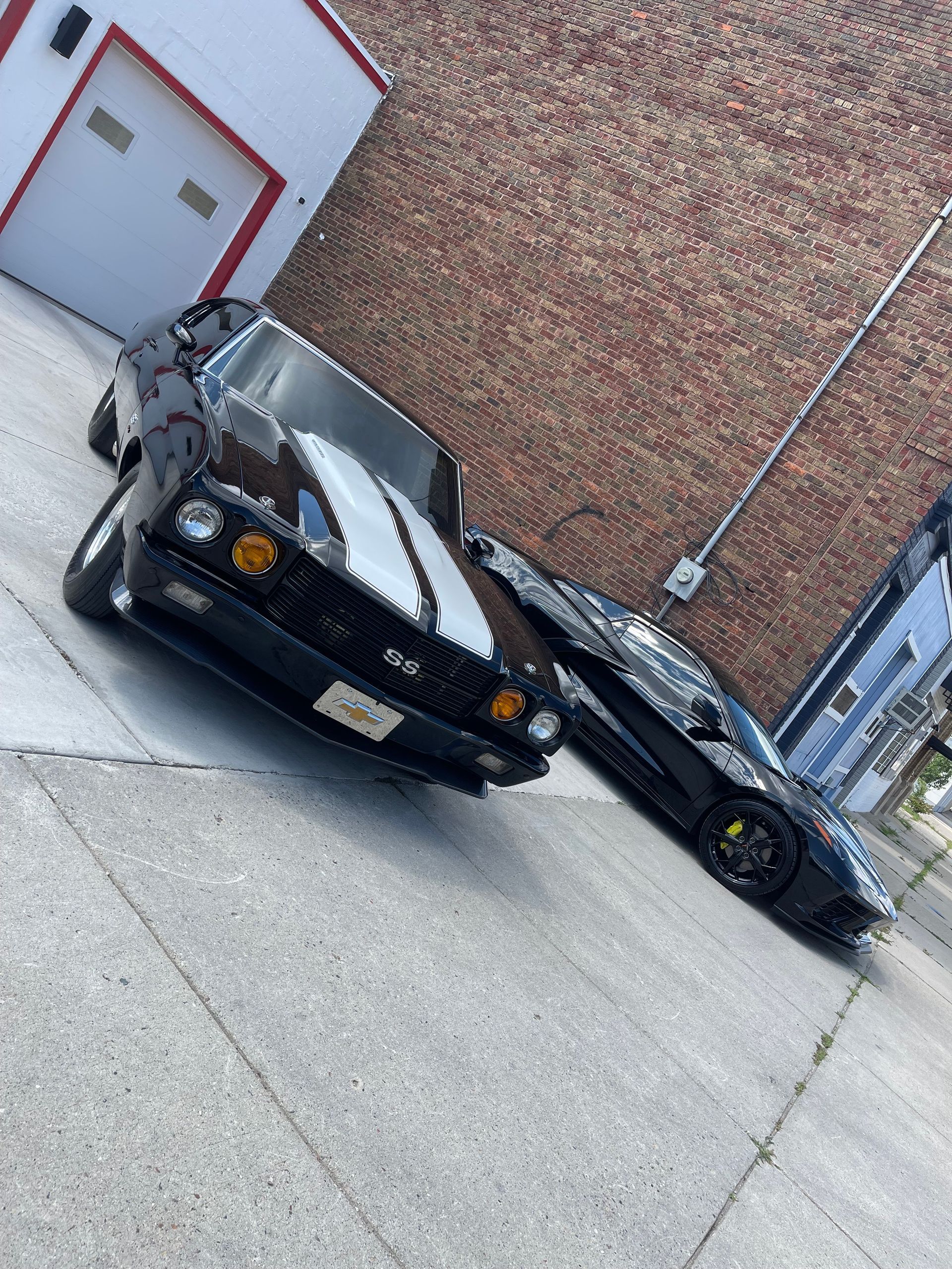 Building exterior with arched window, reflecting sky, beige walls, black window frames.