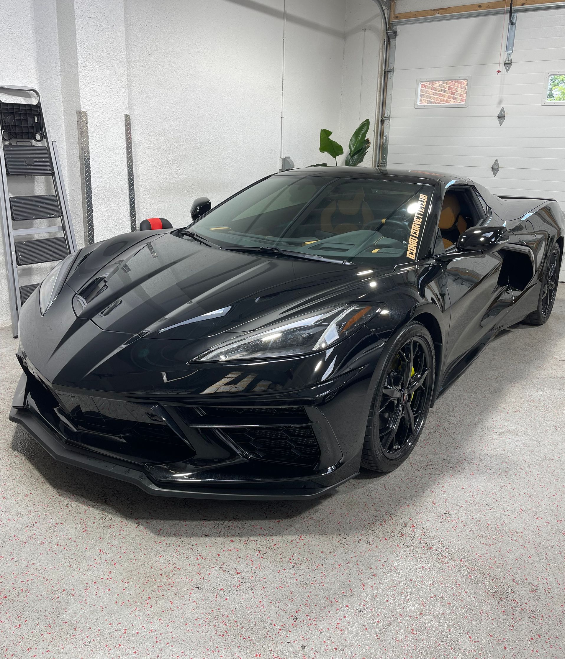 Rivian electric SUV, light green color, with illuminated front light bar, parked indoors.