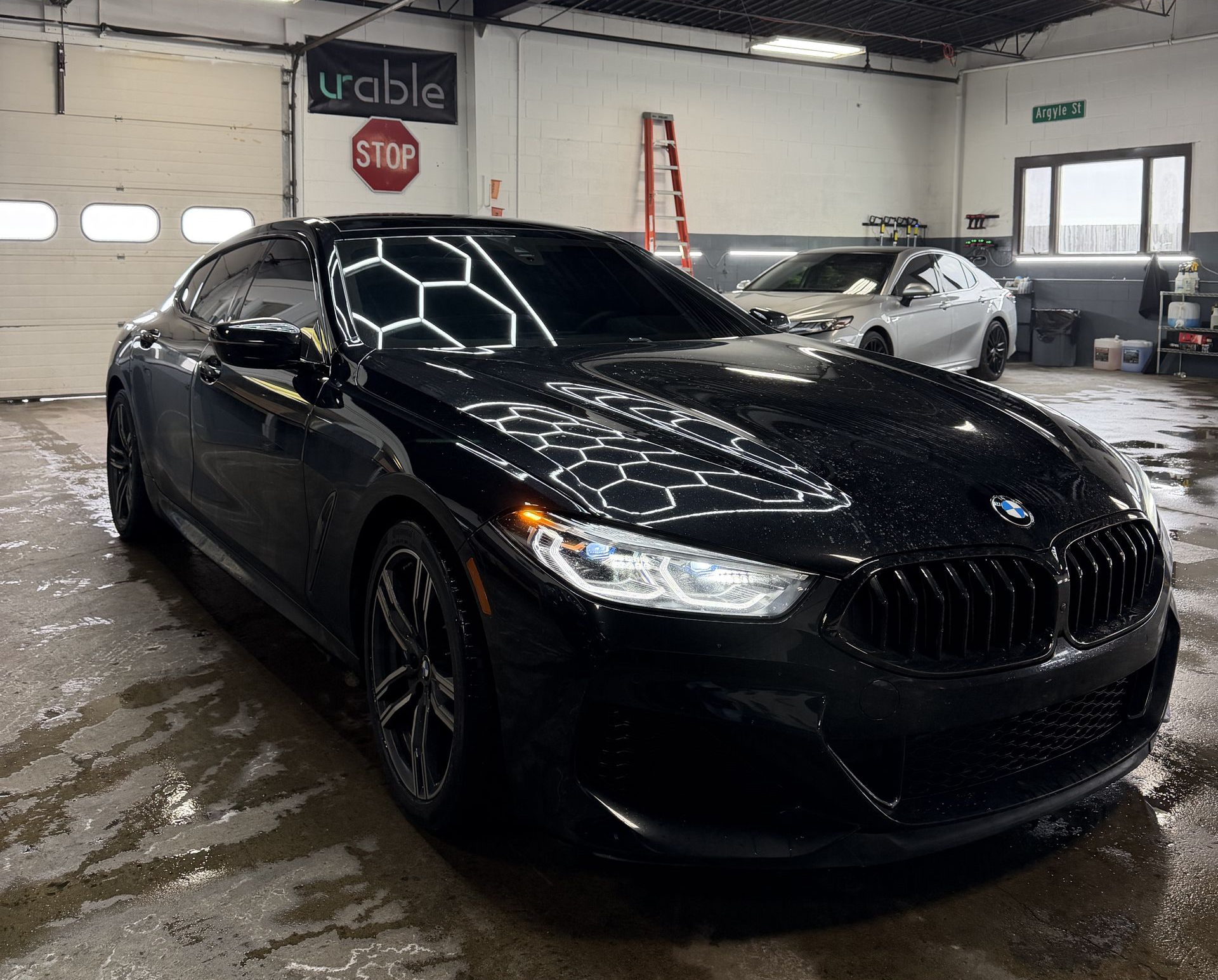 Black GMC Sierra truck parked on wet asphalt.