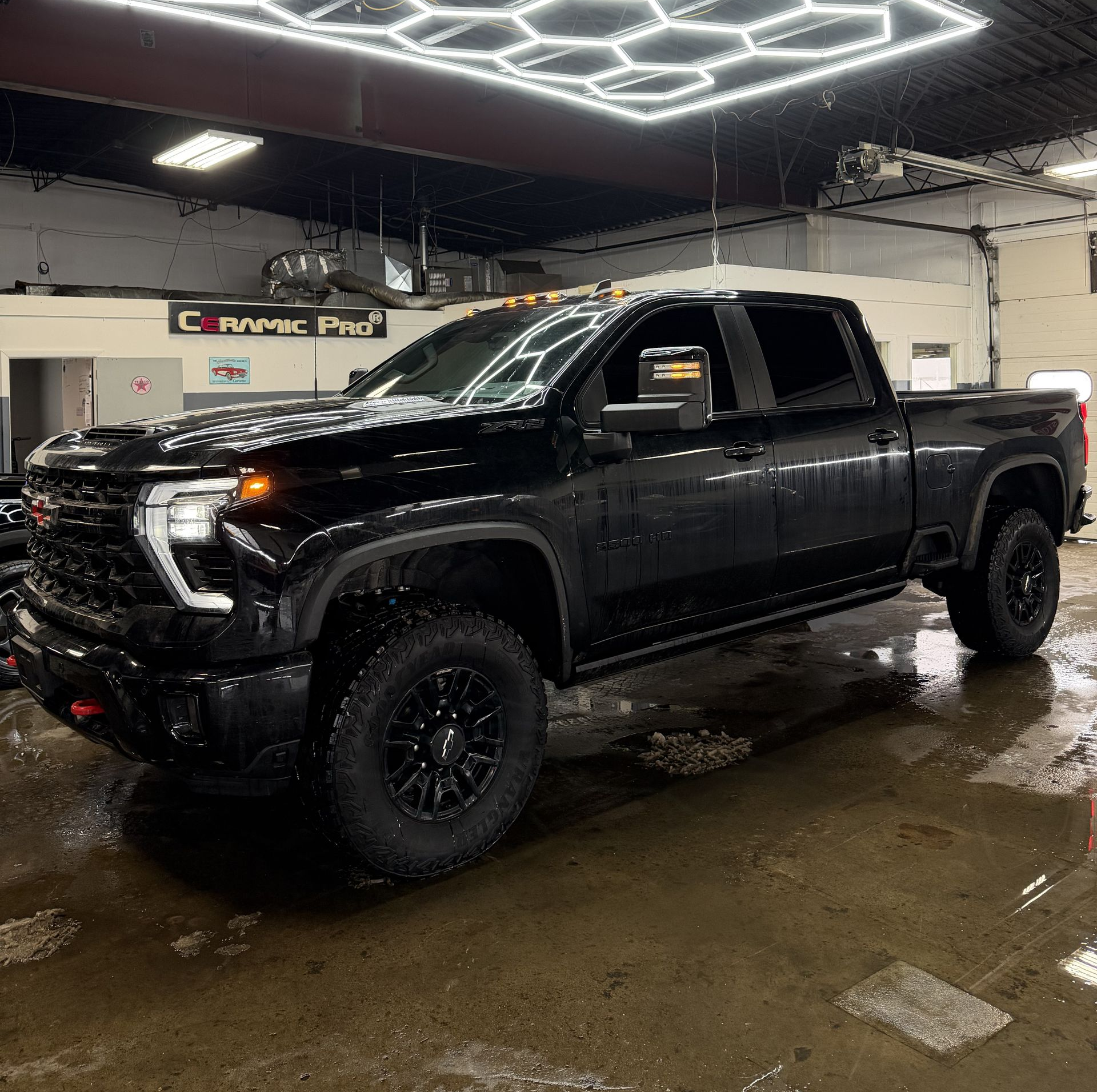 Blue Ford F-150 pickup truck inside a car wash bay under hexagon-shaped lights.