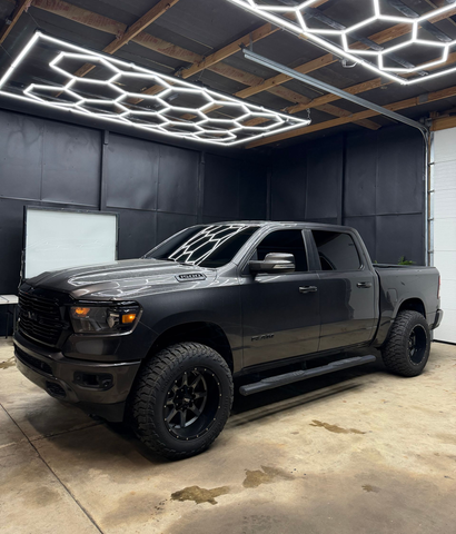 Black GMC Sierra truck parked on wet asphalt.