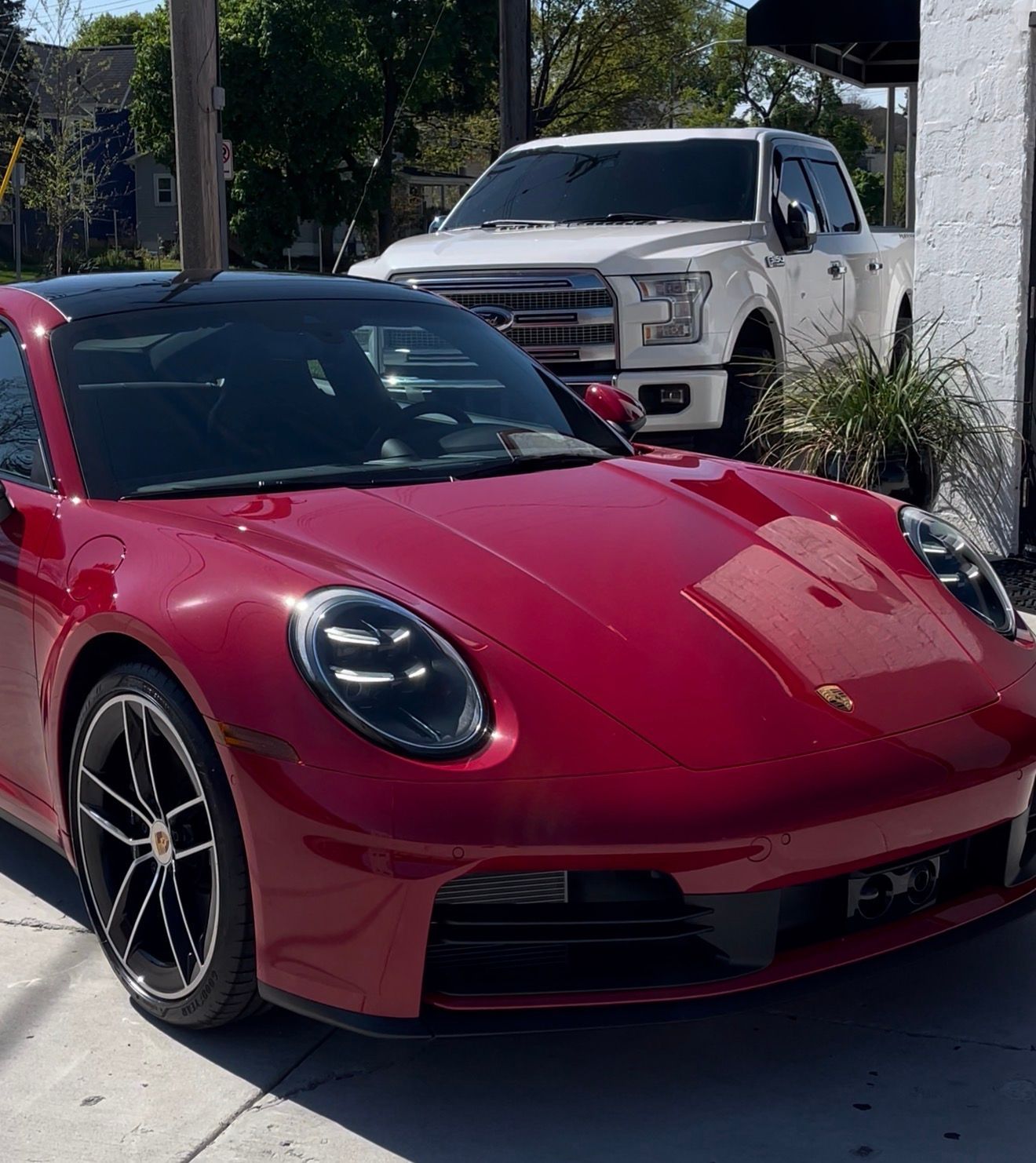 Black BMW X7 SUV parked in front of a modern building with glass doors and windows.