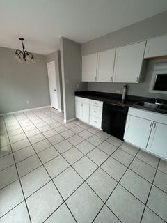 A large white house with black shutters and a gray roof