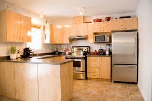 A kitchen with stainless steel appliances and wooden cabinets.