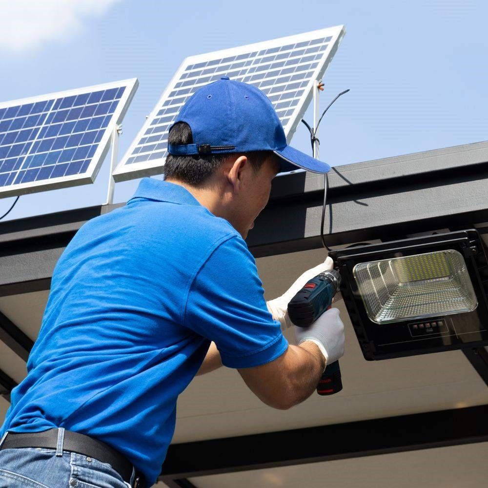 A man in a blue shirt is installing an LED fixture