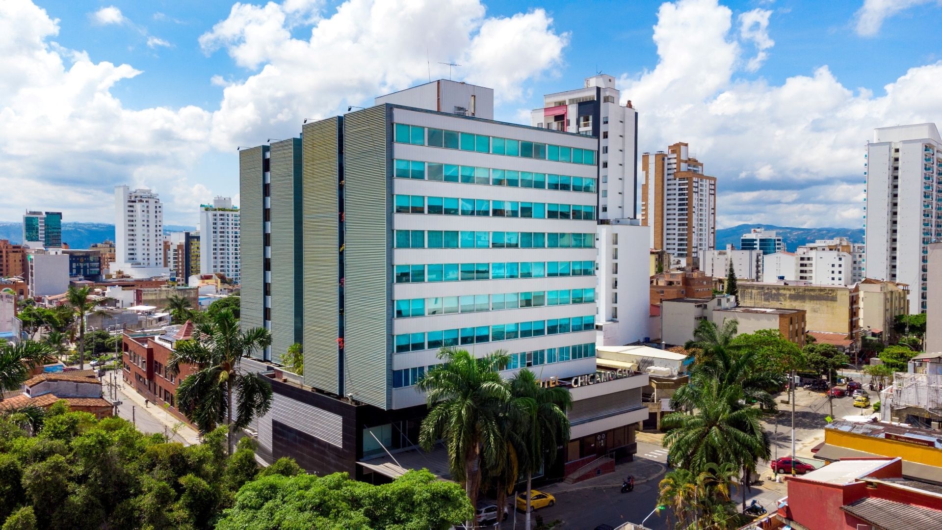 Una vista aérea de un gran edificio en el medio de una ciudad rodeada de árboles.