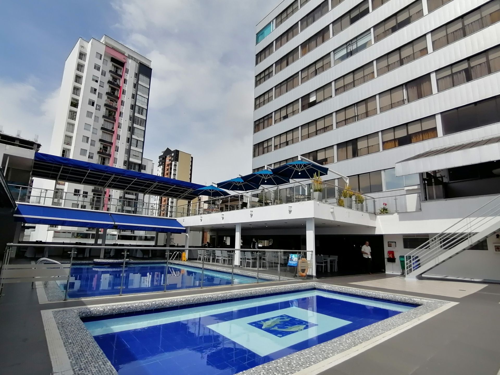 Una gran piscina está frente a un gran edificio.