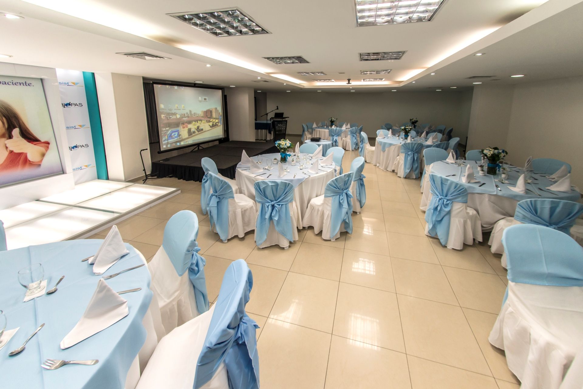 Una gran sala con mesas y sillas preparadas para una fiesta.