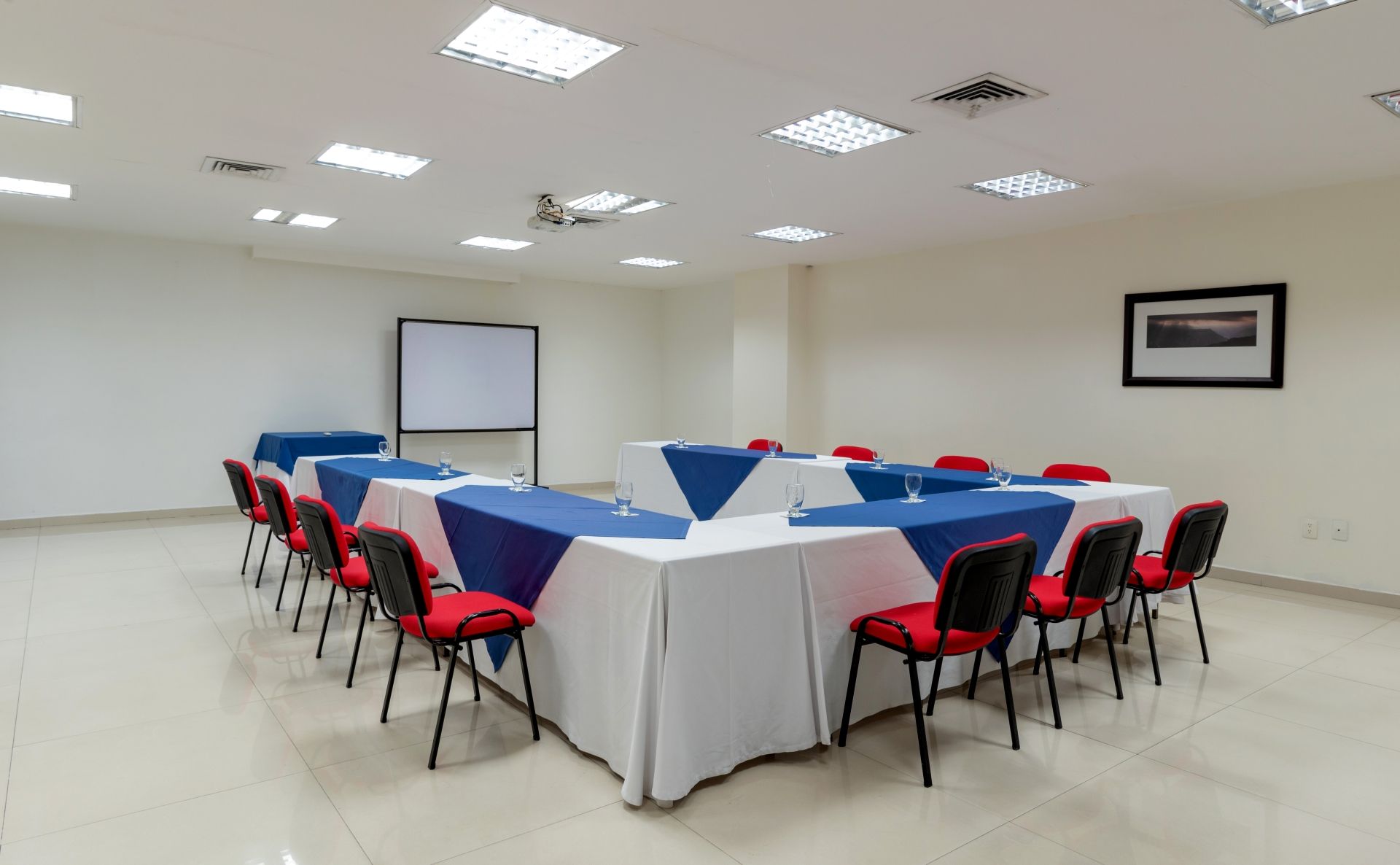 Una sala de conferencias con mesas, sillas y una pizarra.