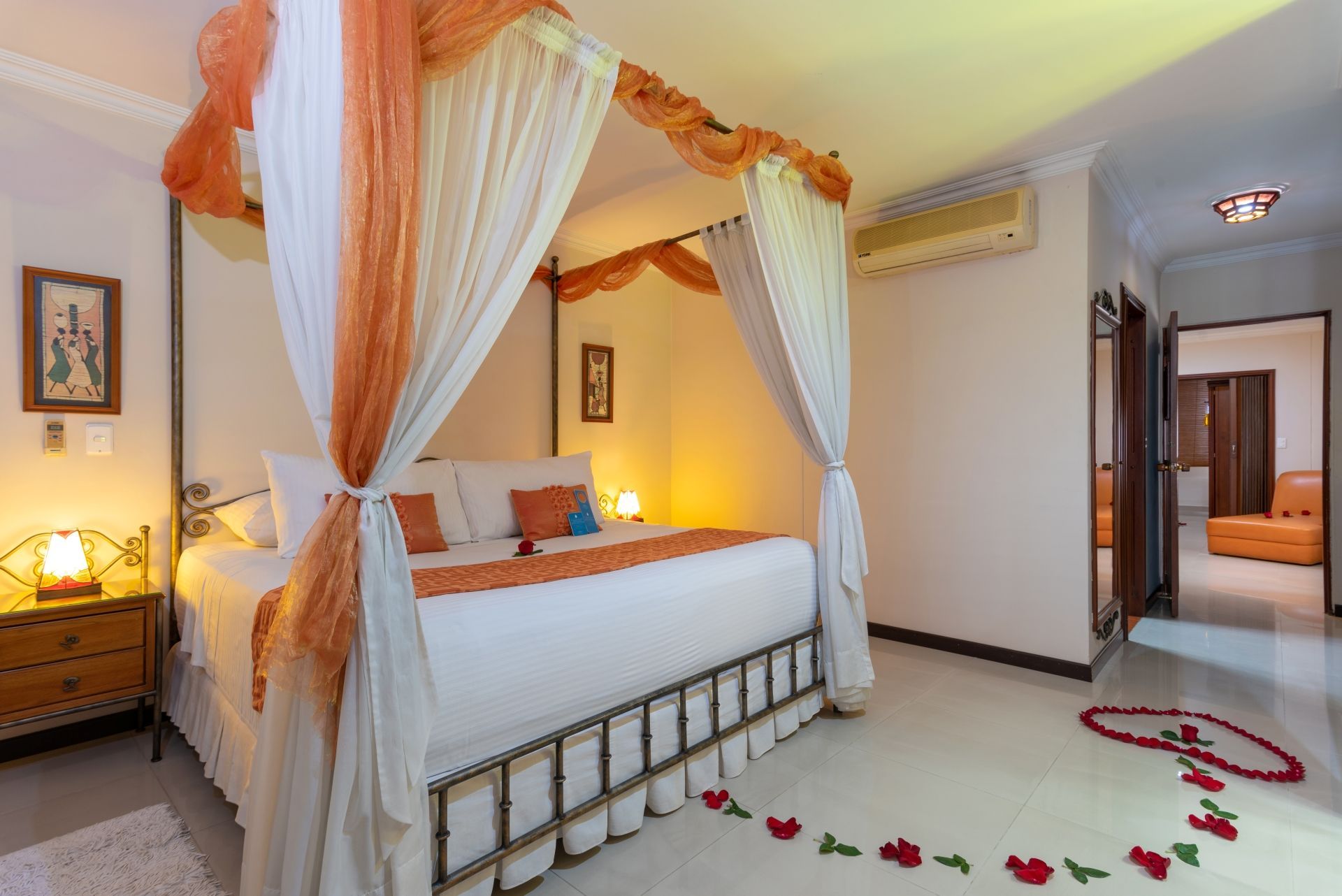 Un dormitorio con una cama con dosel y flores en el suelo.