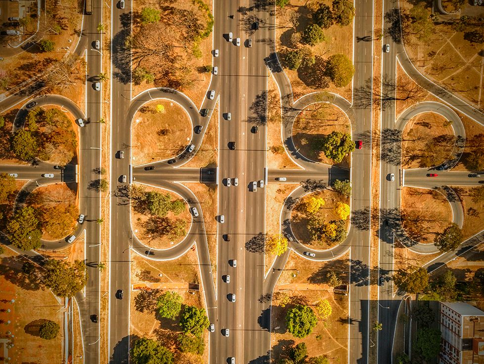 An aerial view of a highway surrounded by trees and buildings.