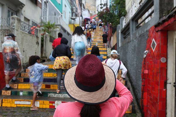 A woman wearing a hat is walking up a set of stairs.