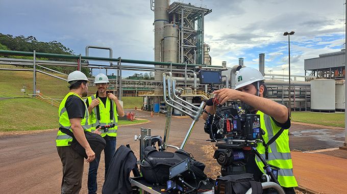 A group of people are standing in front of a factory.