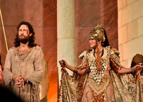 A man and a woman in costume are standing next to each other on a stage.