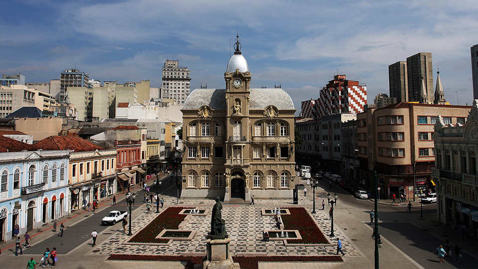 A large building with a clock tower in the middle of a city
