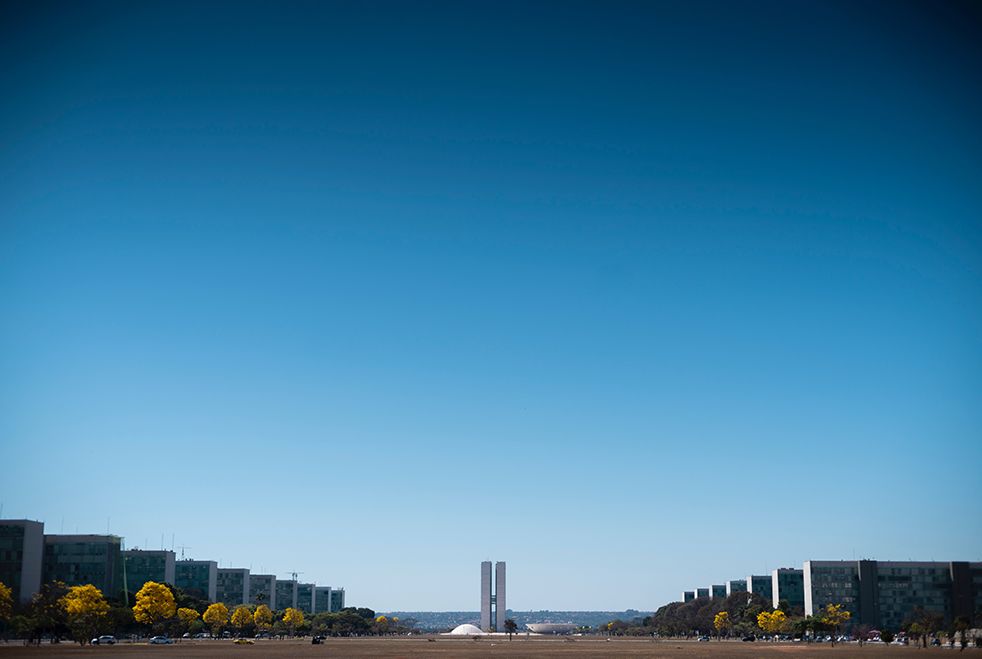 A large building in the middle of a city with a blue sky in the background.