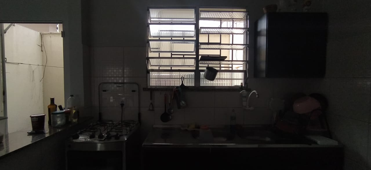A dark kitchen with a sink and a window