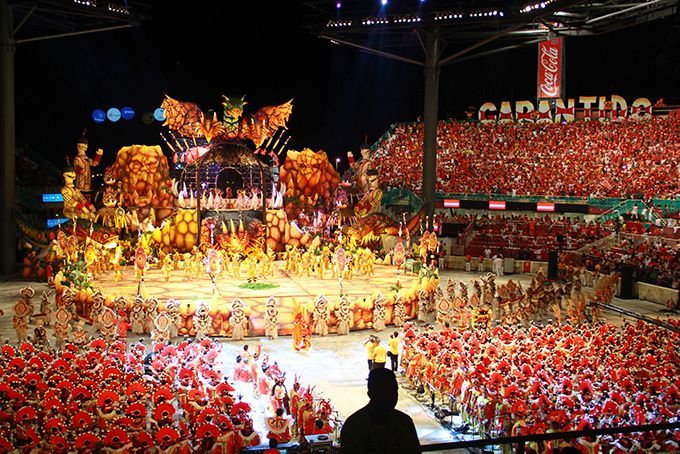 A large crowd of people are watching a carnival show
