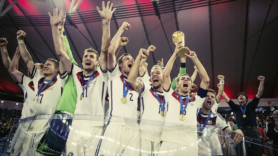 A group of soccer players are holding a trophy in their hands.