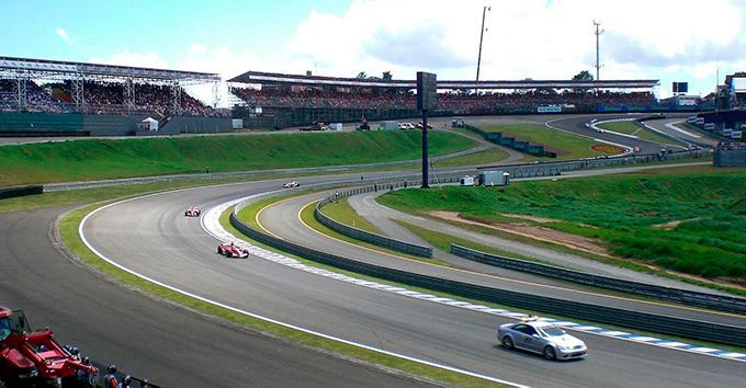 A group of cars are racing on a race track.