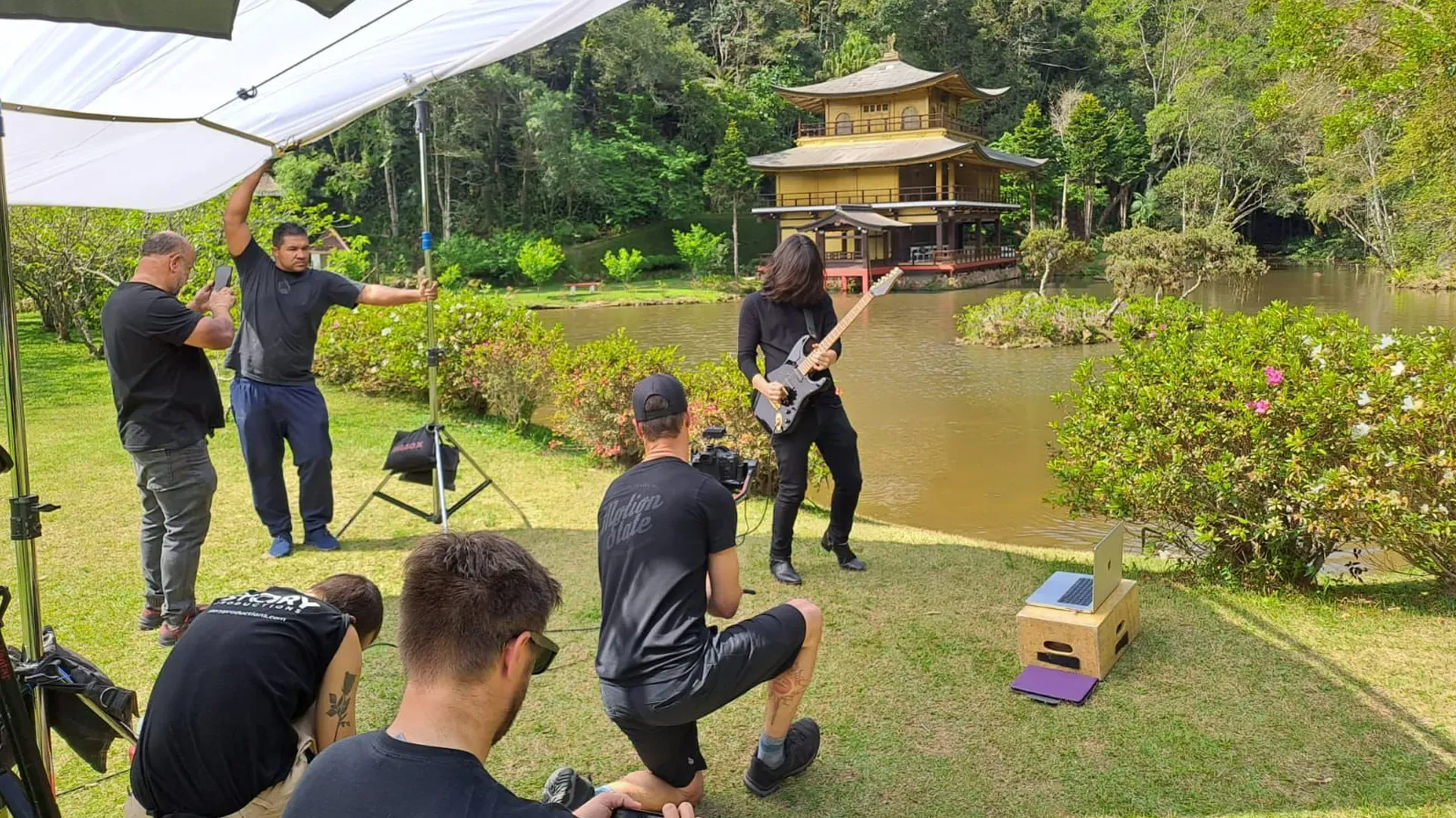 Mateus Asato tocando la guitarra con un templo japonés al fondo