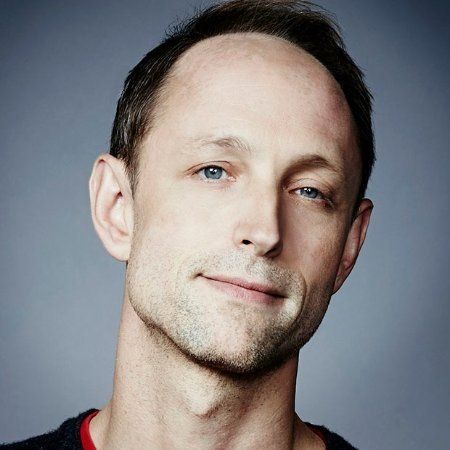 A man with a beard and blue eyes is smiling for the camera