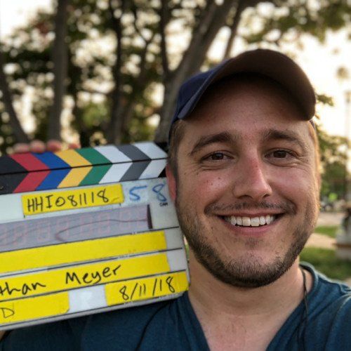 A man holding a clapper board that says brian meyer on it