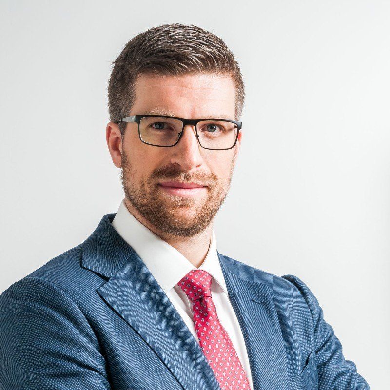 A man in a suit and tie is wearing glasses