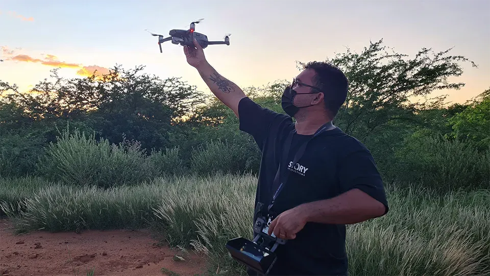 Man holding a drone above his head, getting ready to fly it