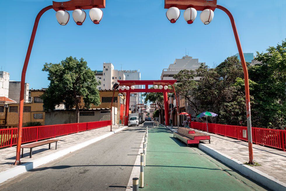A street with a red fence and a green bike lane