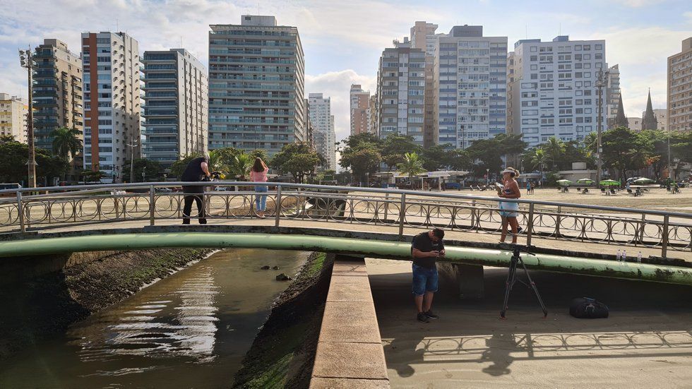A group of people are standing on a bridge over a river.