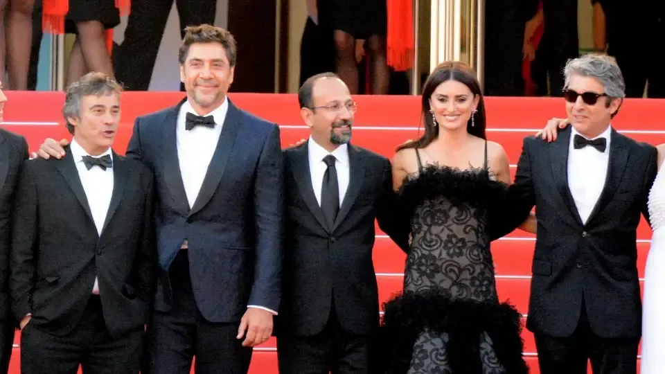 A group of people standing next to each other on a red carpet.