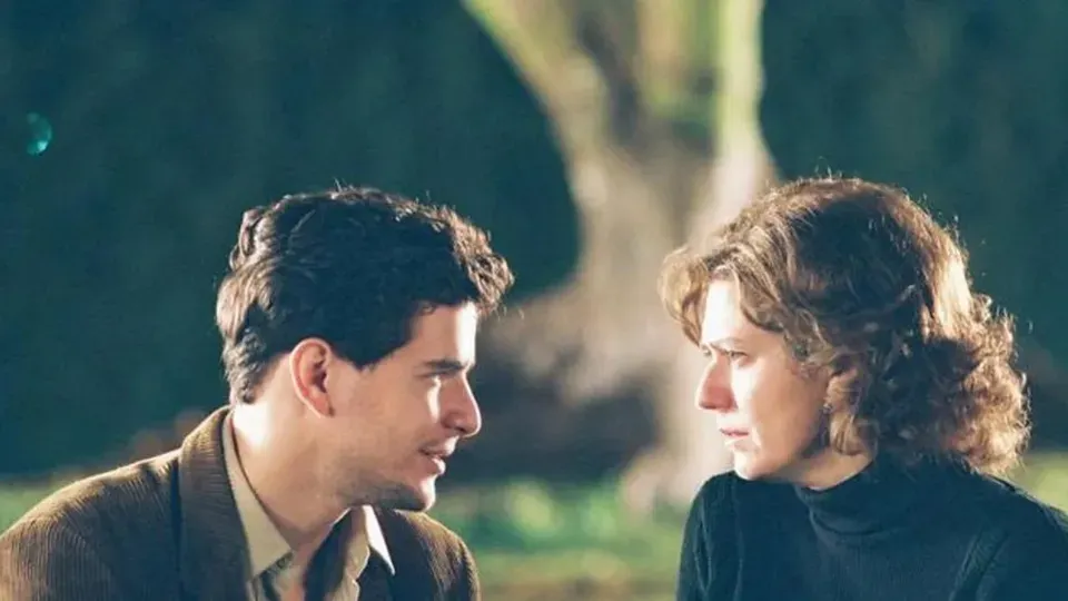 A man and a woman are looking at each other in a park.