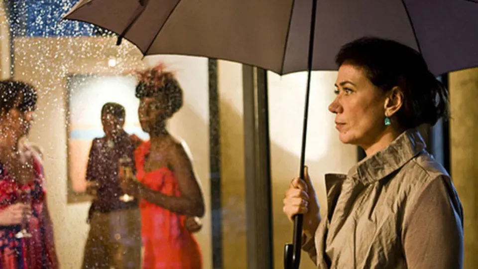 A woman is holding an umbrella while standing in the rain.