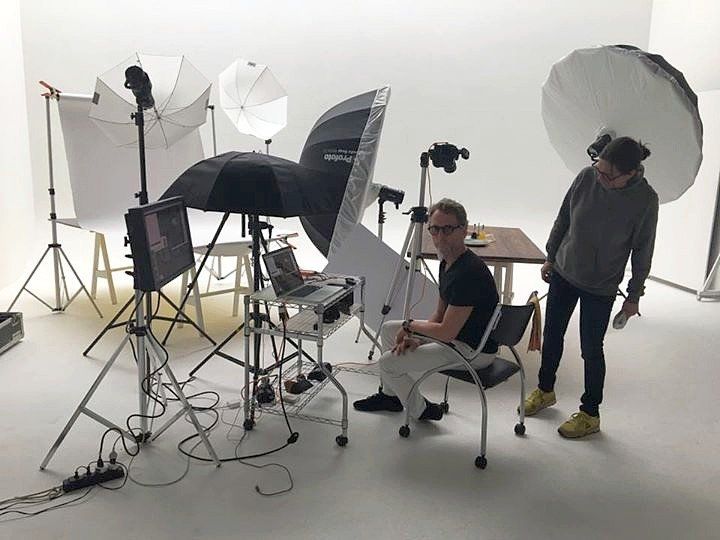 A man is sitting in a chair in a photo studio
