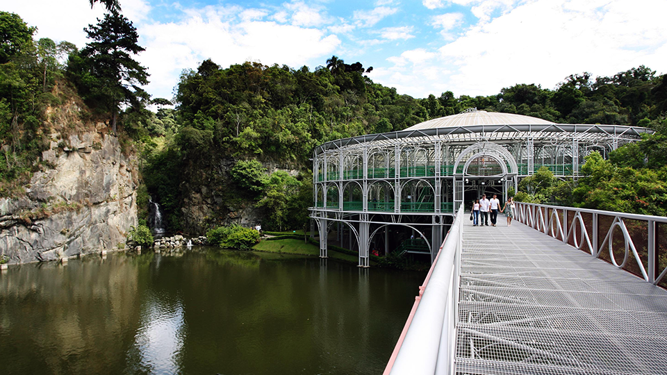 A front view of Santos' leaning buildings A bridge over a lake with a building in the background.