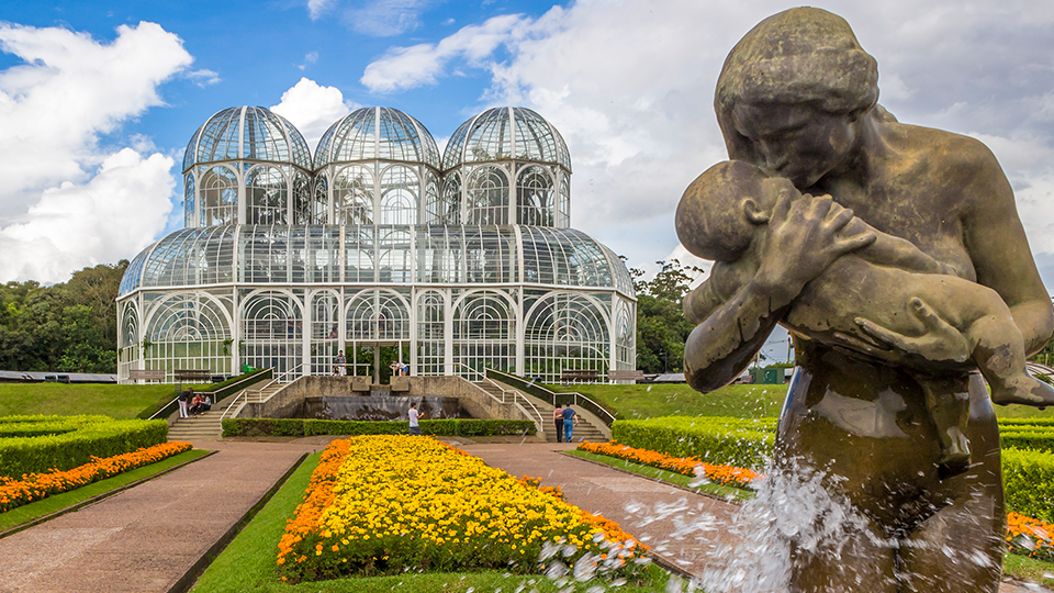 A statue of a woman holding a baby in front of a building.
