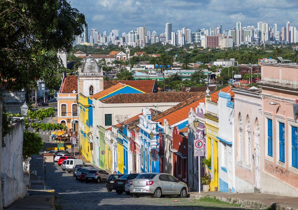A row of colorful buildings with a city in the background