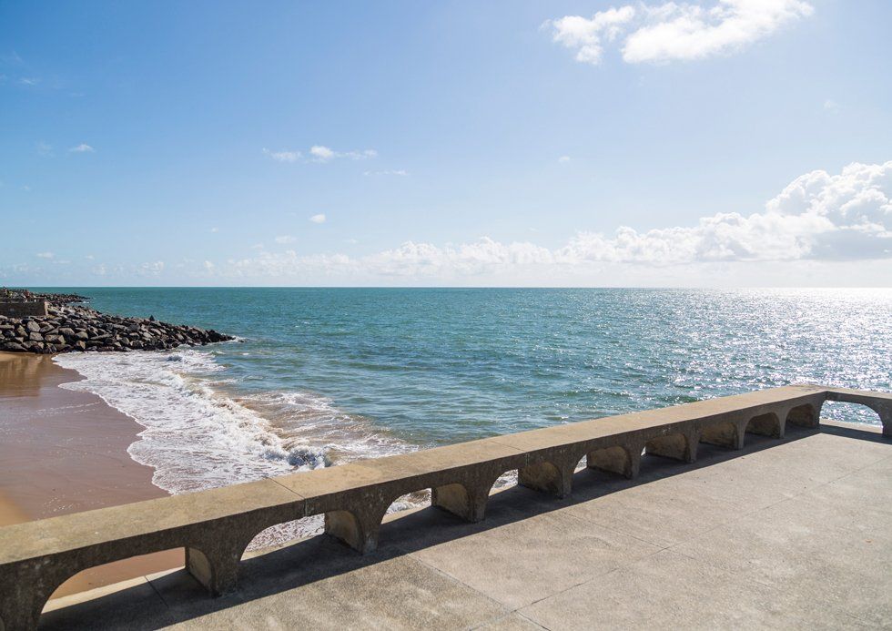 A view of the ocean from a pier on a sunny day.