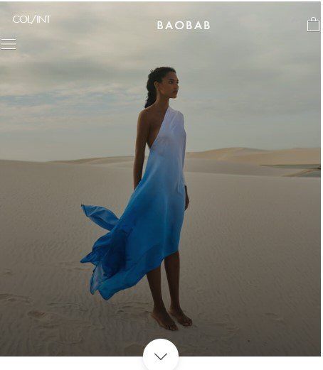 A woman in a blue and white dress is standing in the desert