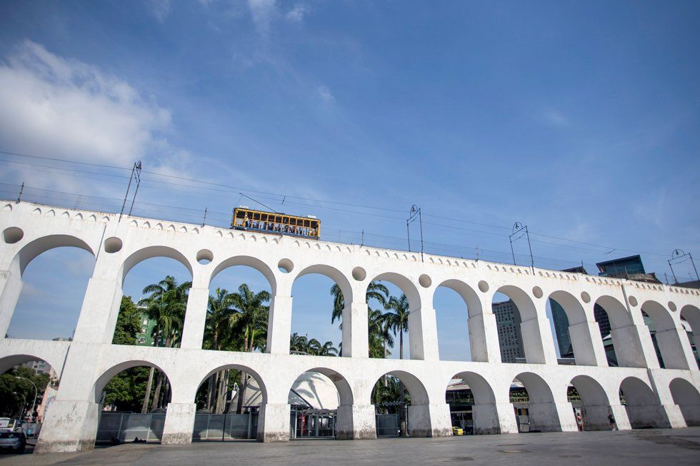 A bridge with arches and a train going over it.