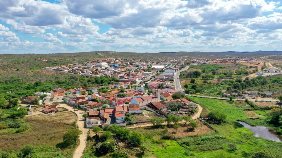 An aerial view of a small town in the middle of a lush green field.