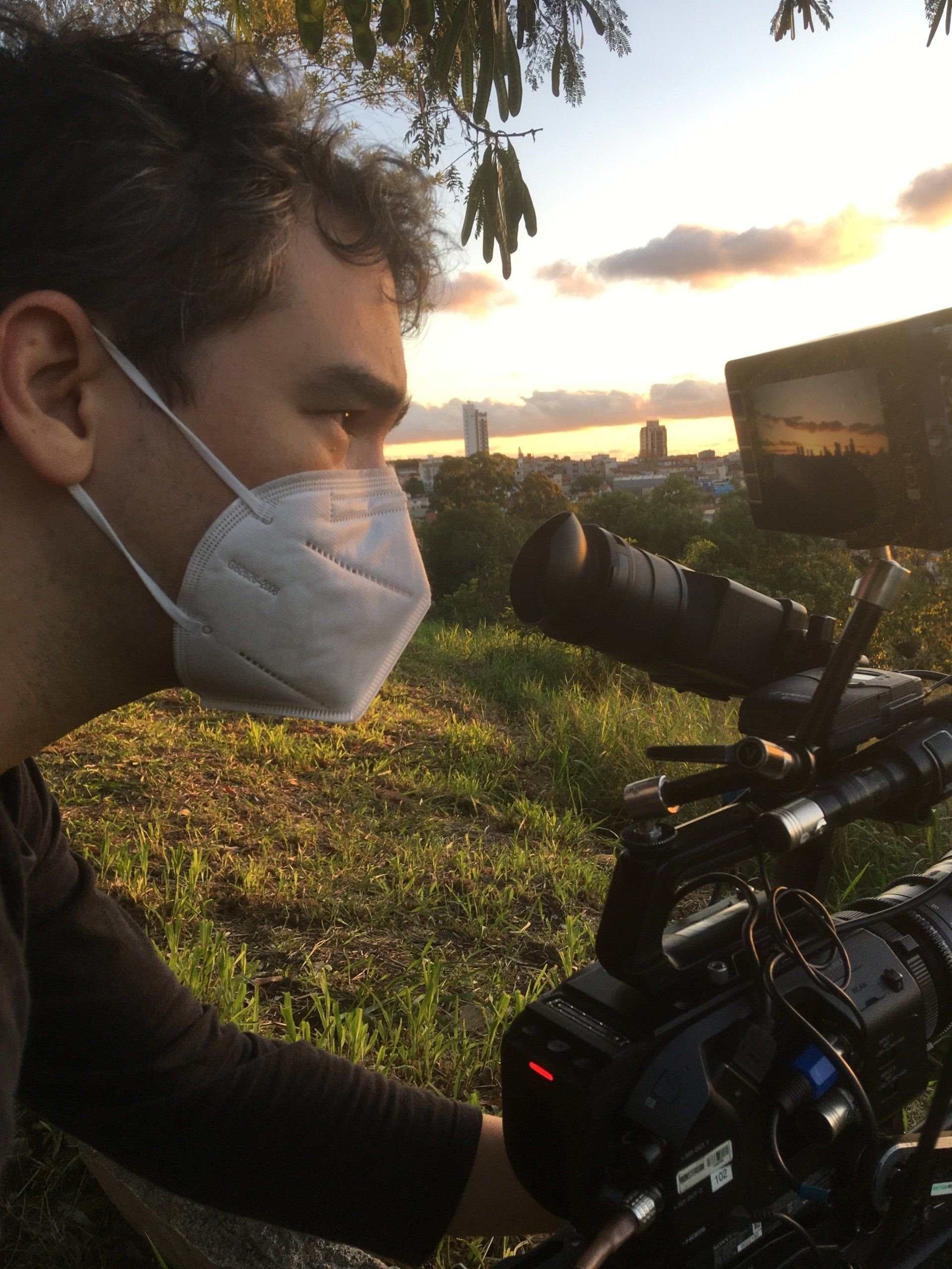 A man wearing a mask is looking at a camera