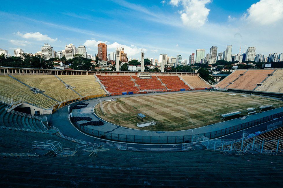An empty soccer stadium with a city in the background.