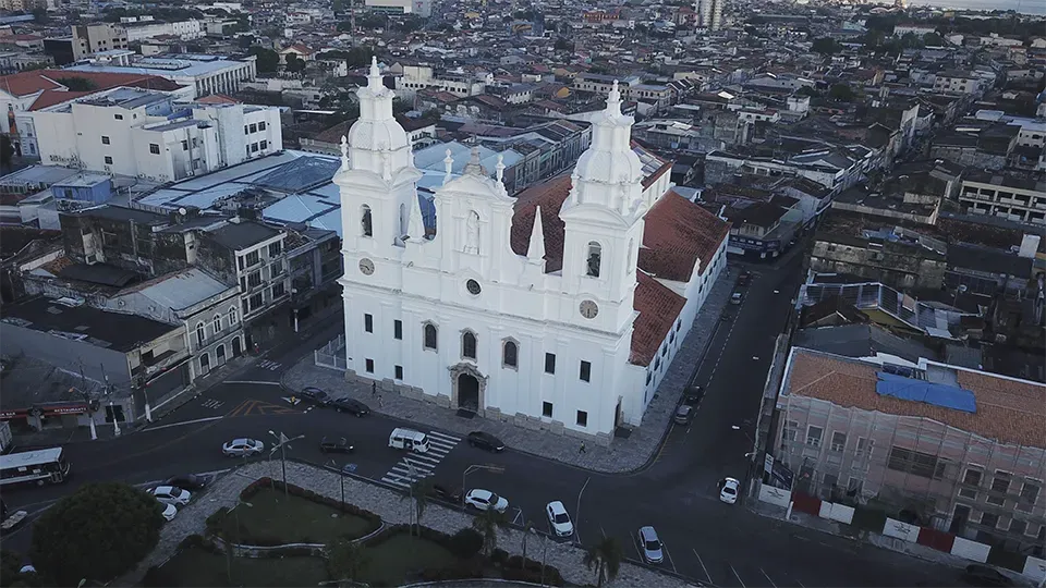 An aerial view of a large white building in the middle of a city.