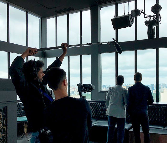 A group of people are standing in front of a large window.