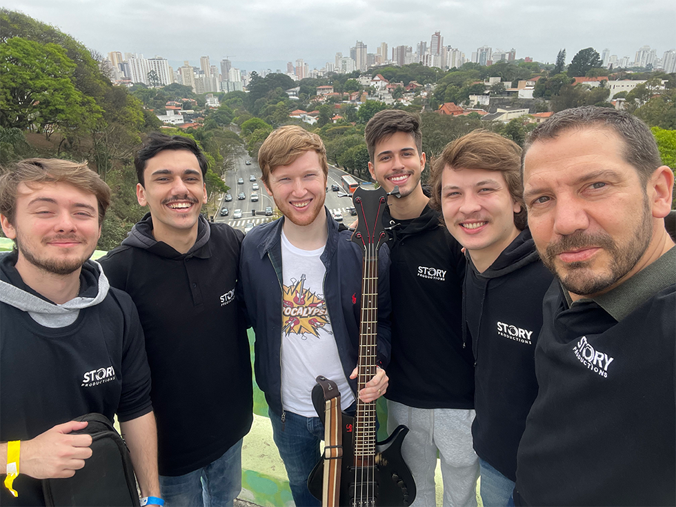A group of young men are posing for a picture while one of them is holding a guitar.