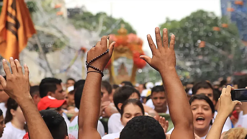 A crowd of people with their hands in the air.