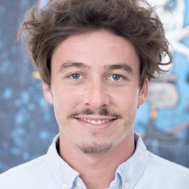 A man with a beard and a white shirt is smiling for the camera.