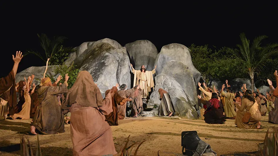 A group of people are standing around a statue of jesus.